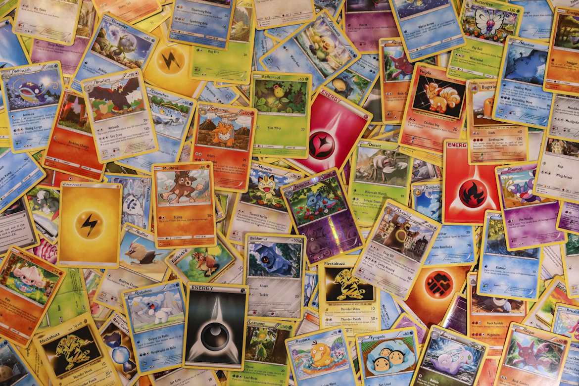 A numerous amount of Pokémon cards strewn across a surface revealing different types from different generations.